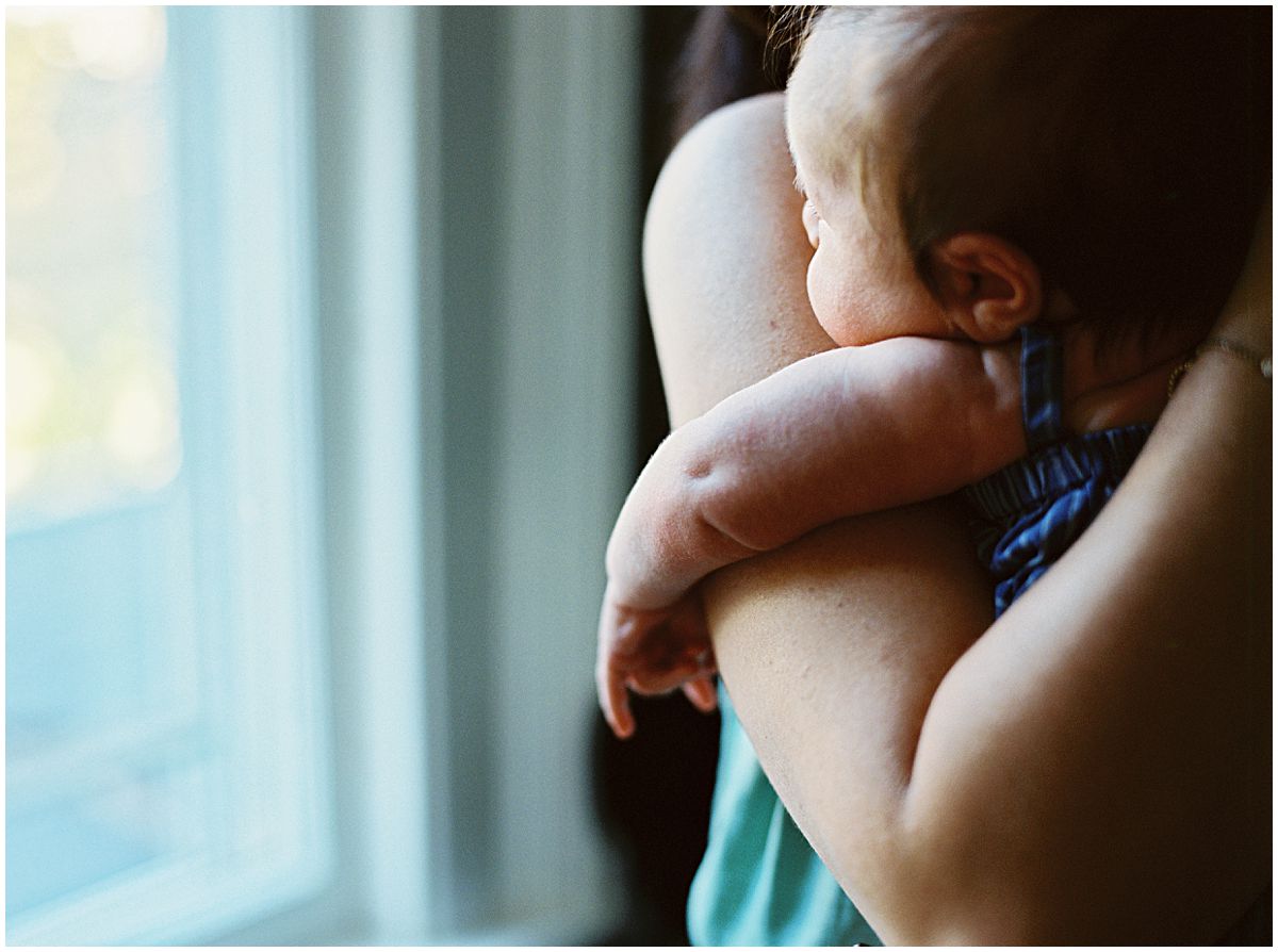 mom holding little baby in her arms in newborn photography session in NYC