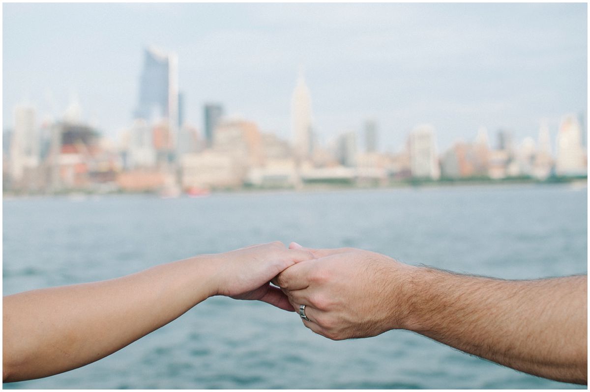 mom and dad hold hands in a family portrait by NYC Skyline