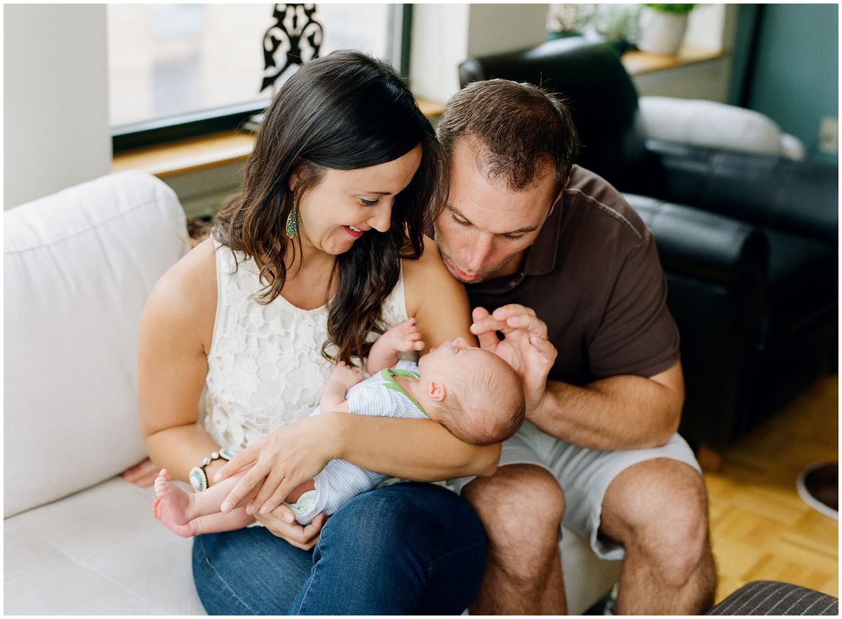 mom and dad looking adoringly a their newborn baby funny facial expressions