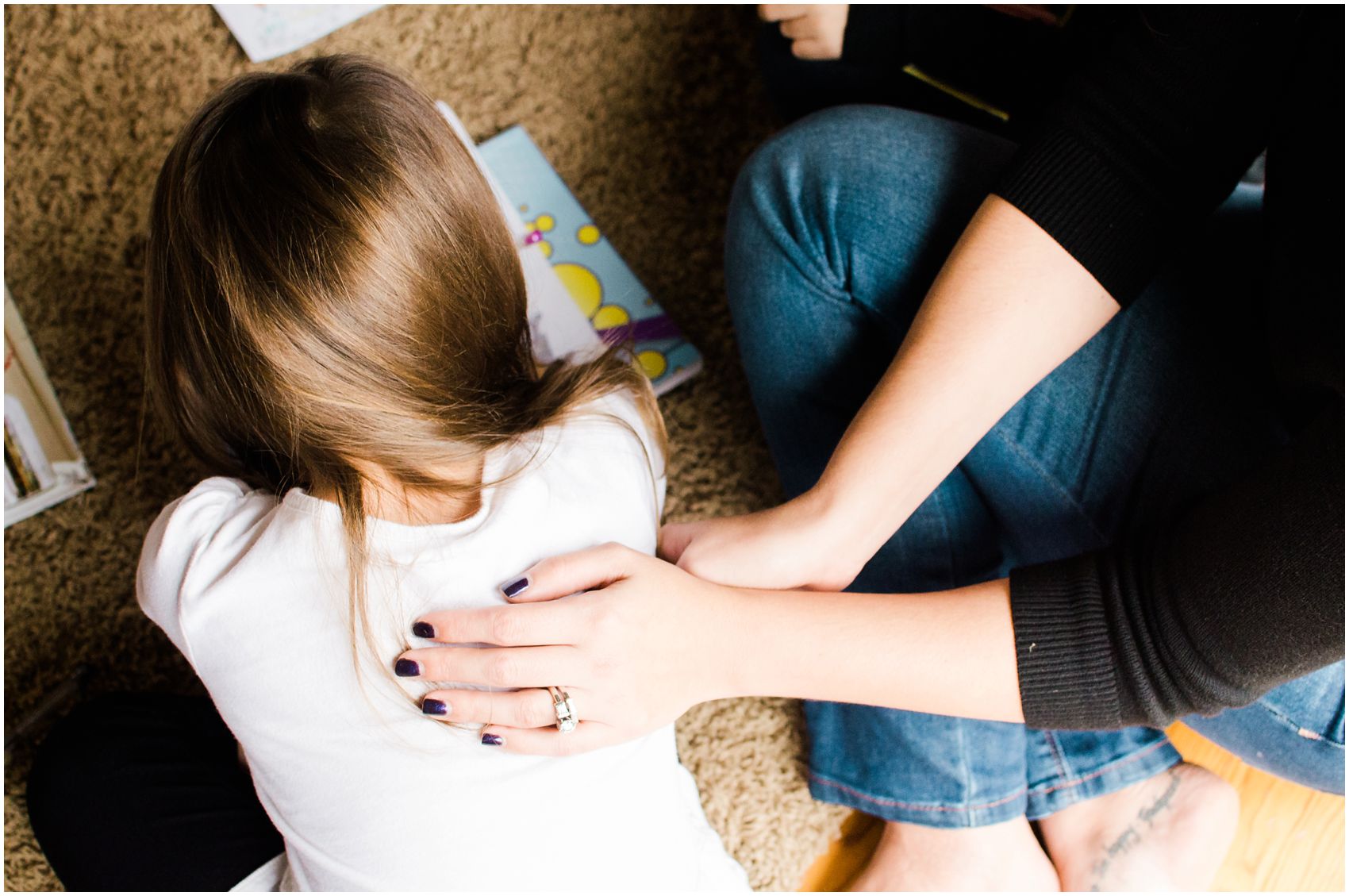 Motherhood portrait of mom lovingly patting her daughter's back in New Jersey home