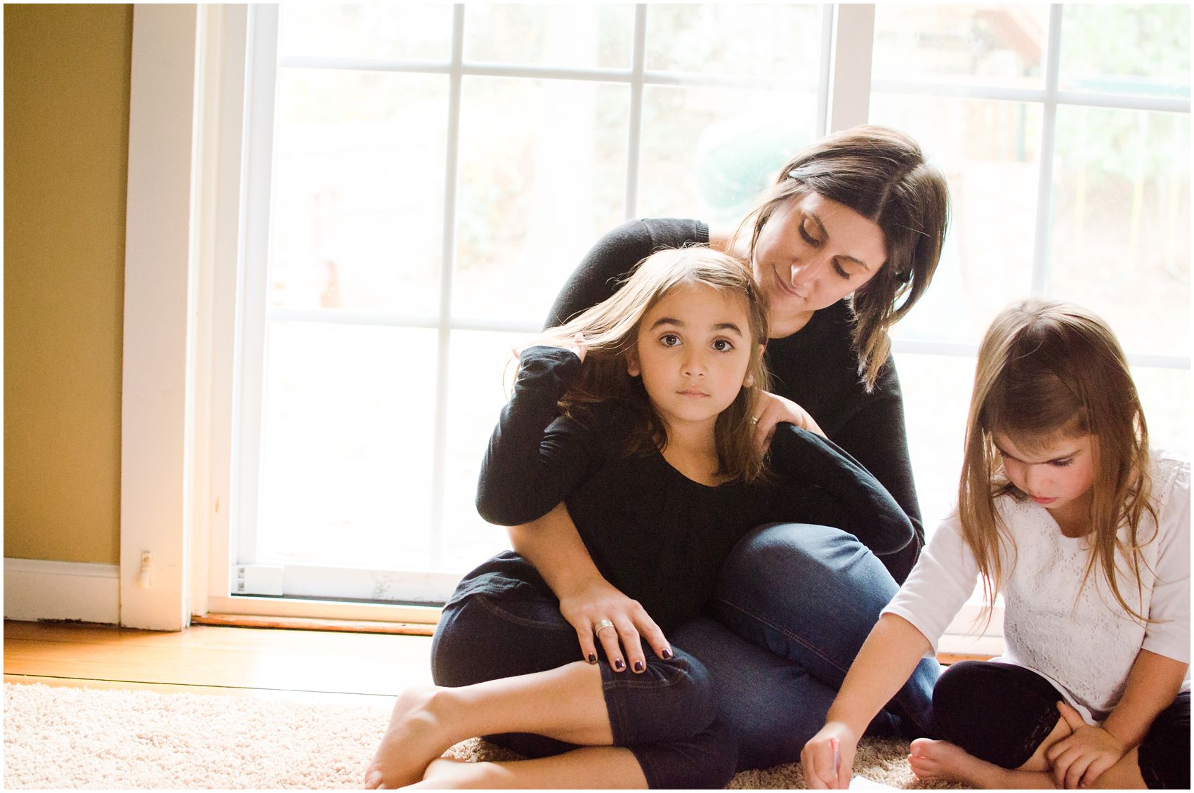 Motherhood and Family Photography with mother and two daughters snuggling together in Tenafly , NJ home