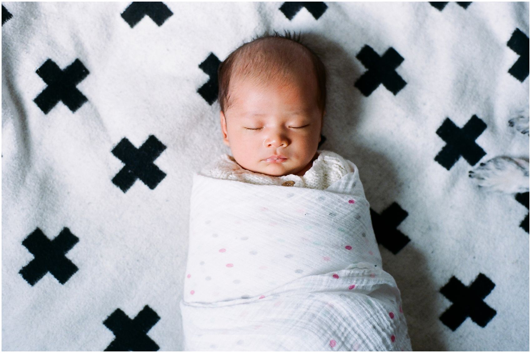 Newborn Photography NYC with a 3 weeks old sleeping baby girl on the floor with the dogs feet