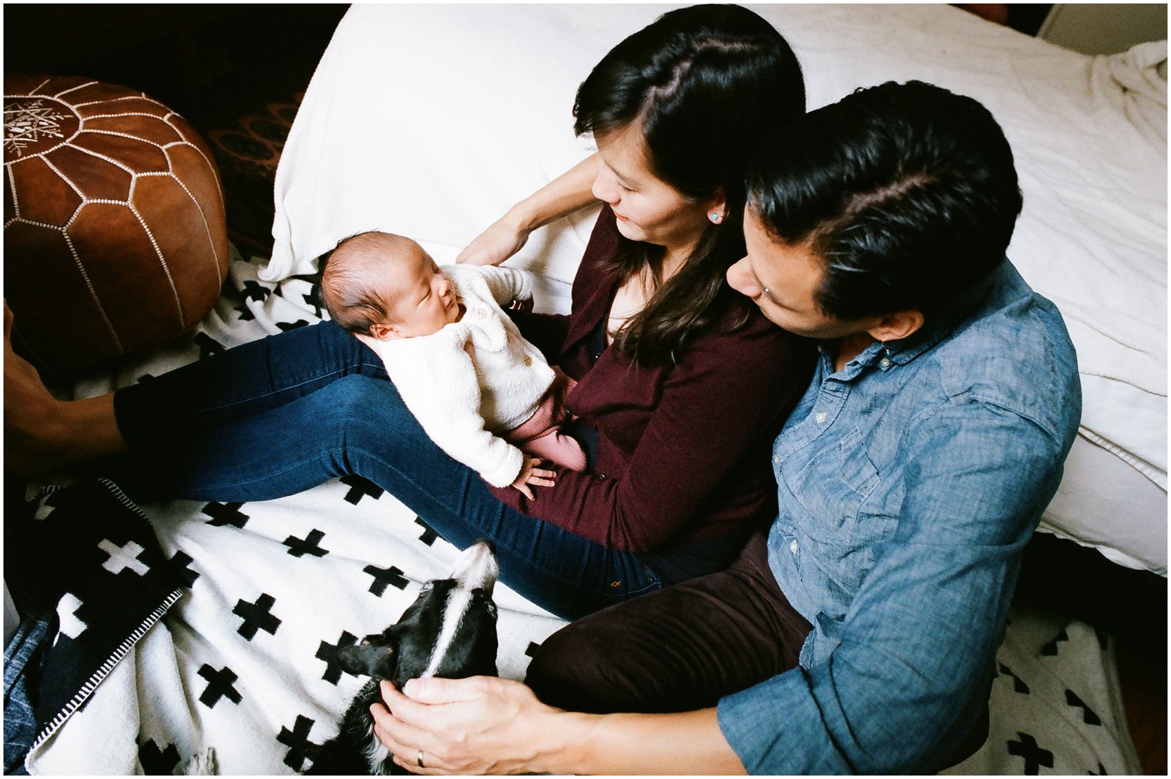 new baby on the lap with mom and dad around 3 weeks of age for the best time to do newborn photography