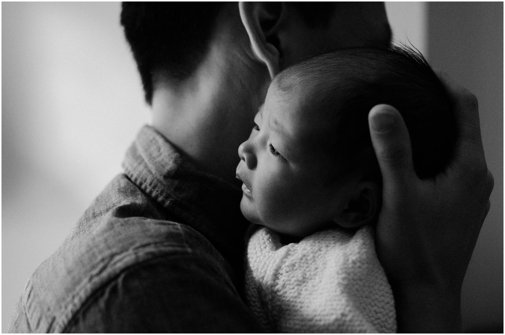 dad hugging his new baby daughter in newborn portraits by Miriam Dubinsky
