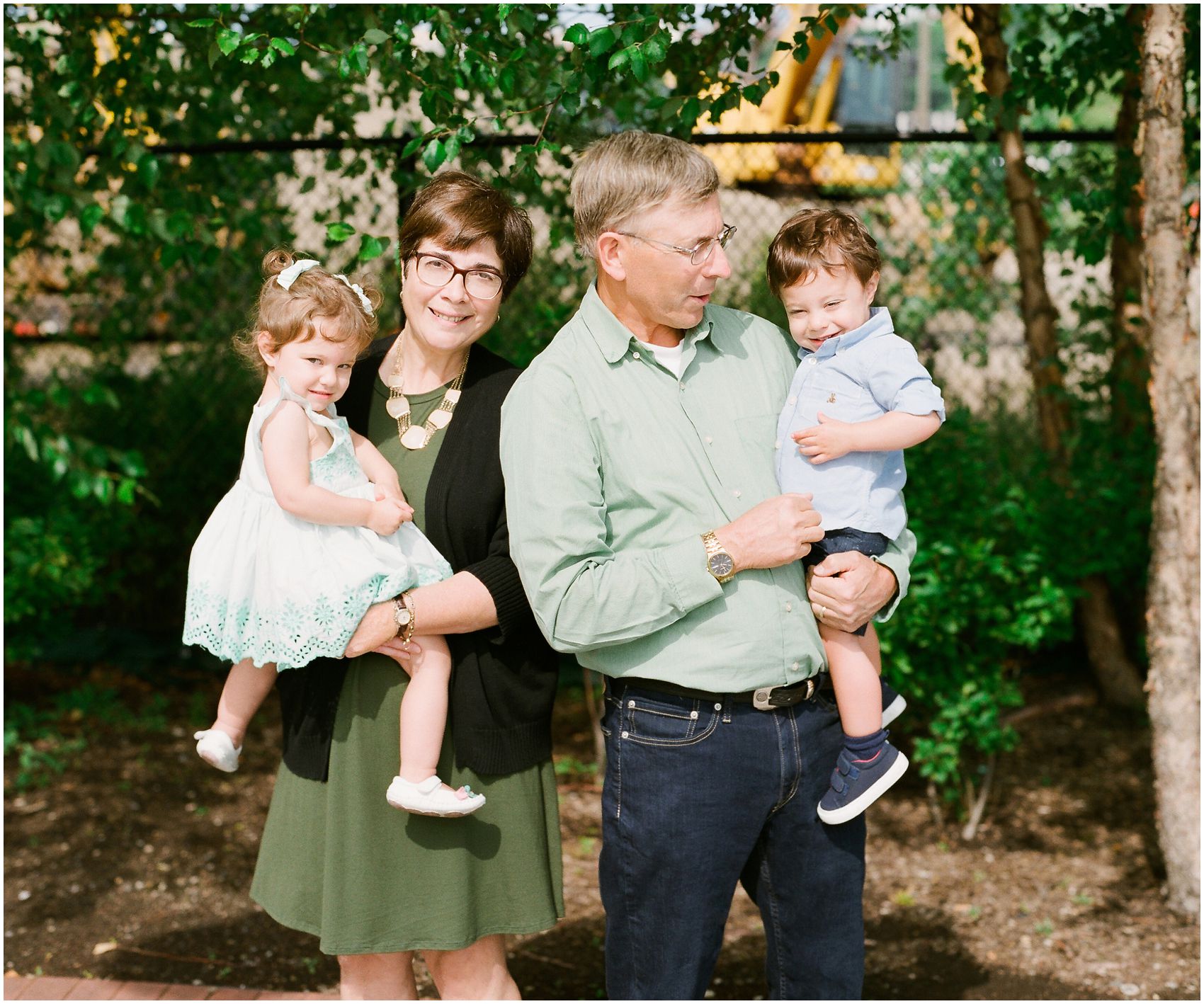 photo session of grandparents and grandchildren against  green scenery of Hoboken NJ