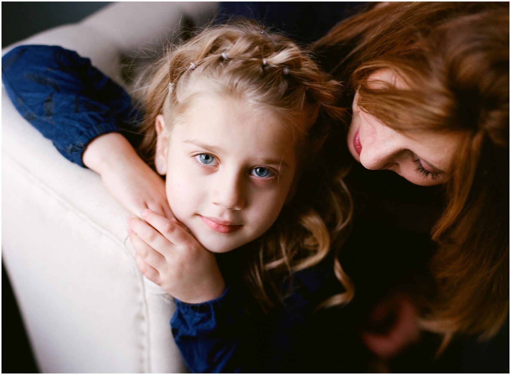 blond girl with blue eyes sitting with her mom