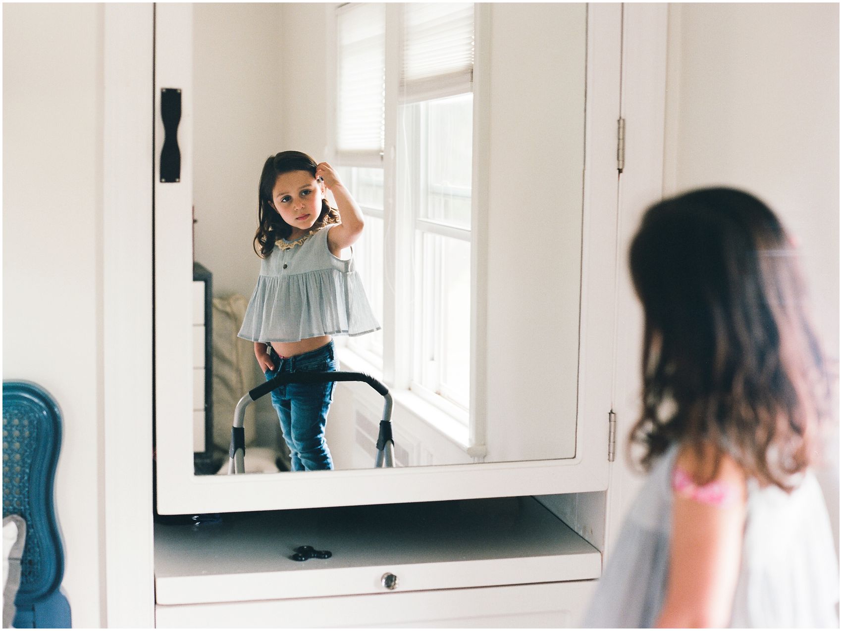 little girl fixing her hair in the mirror at NJ home for family portraits