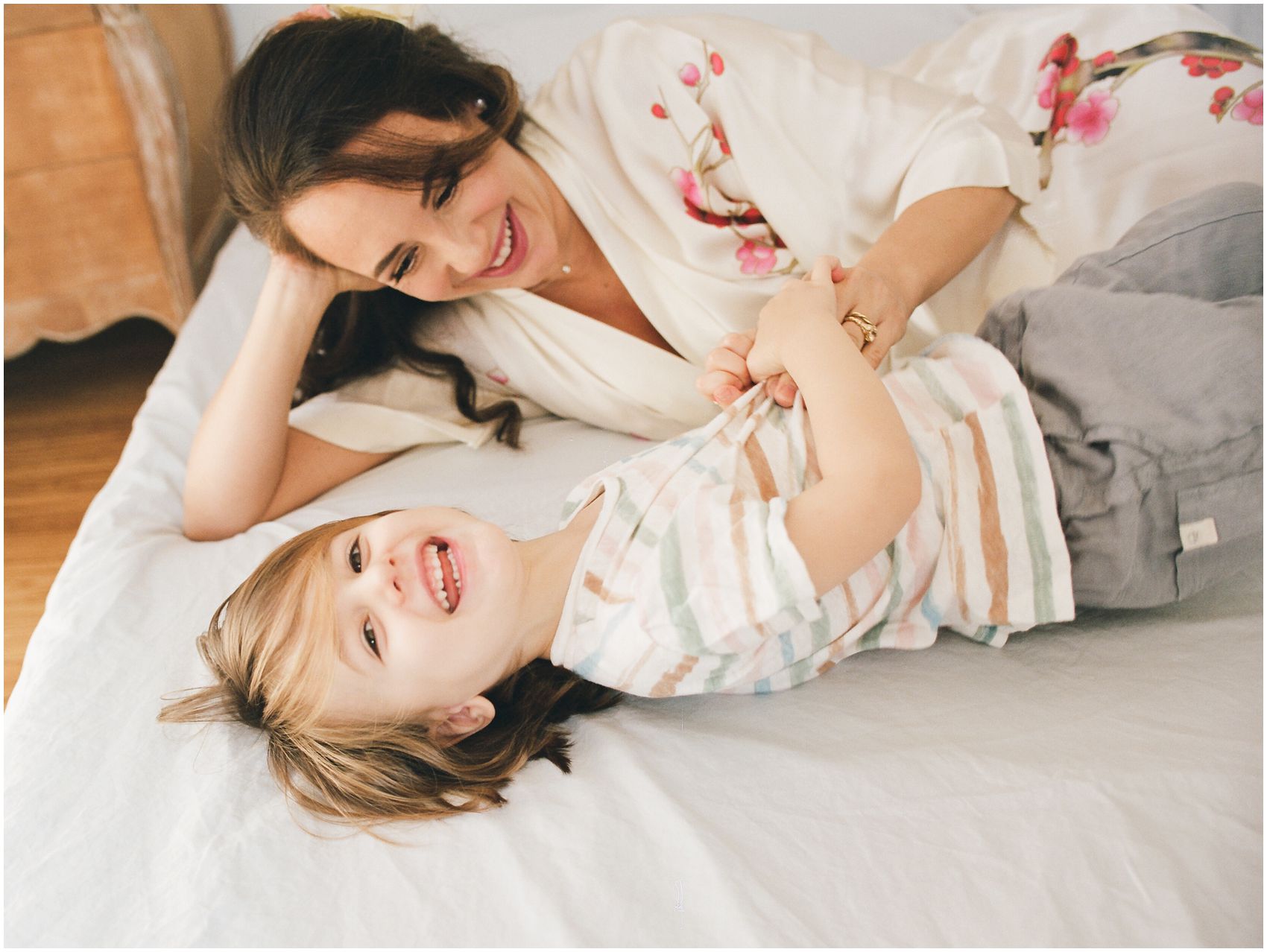 mommy and son laughing in bed during family photos in Montclair NJ