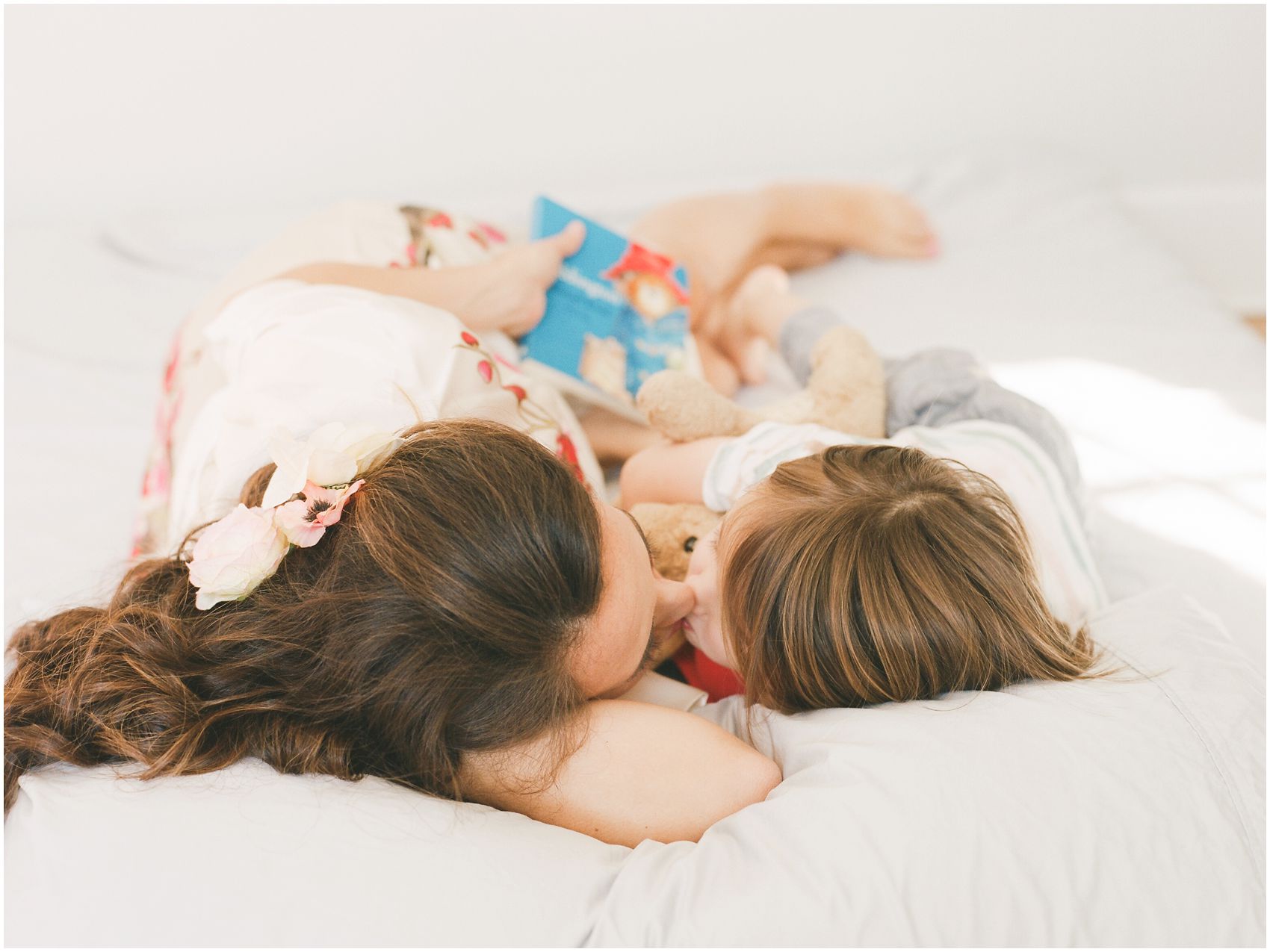 mommy and son giving kisses in bed captured by NYC Family Photographer