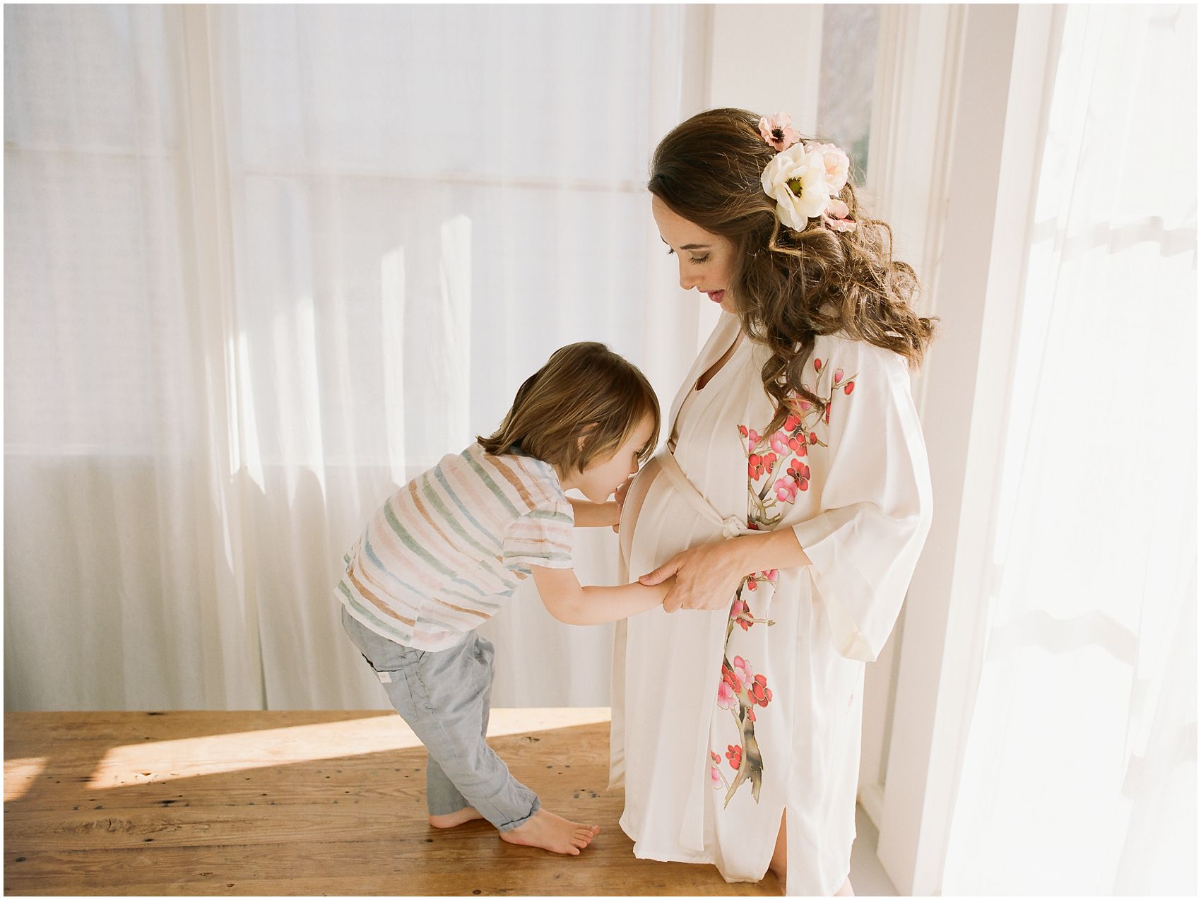 Maternity photos with big brother talking to his baby sister in the belly