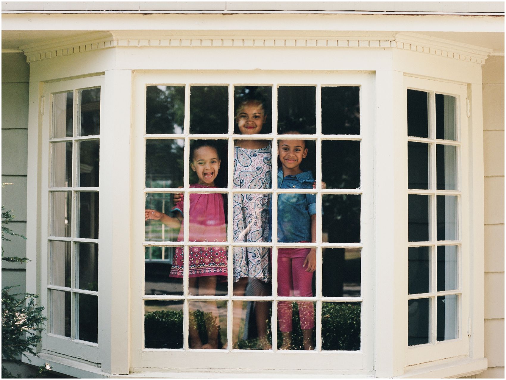 girls looking out in the window of their New Jersey home