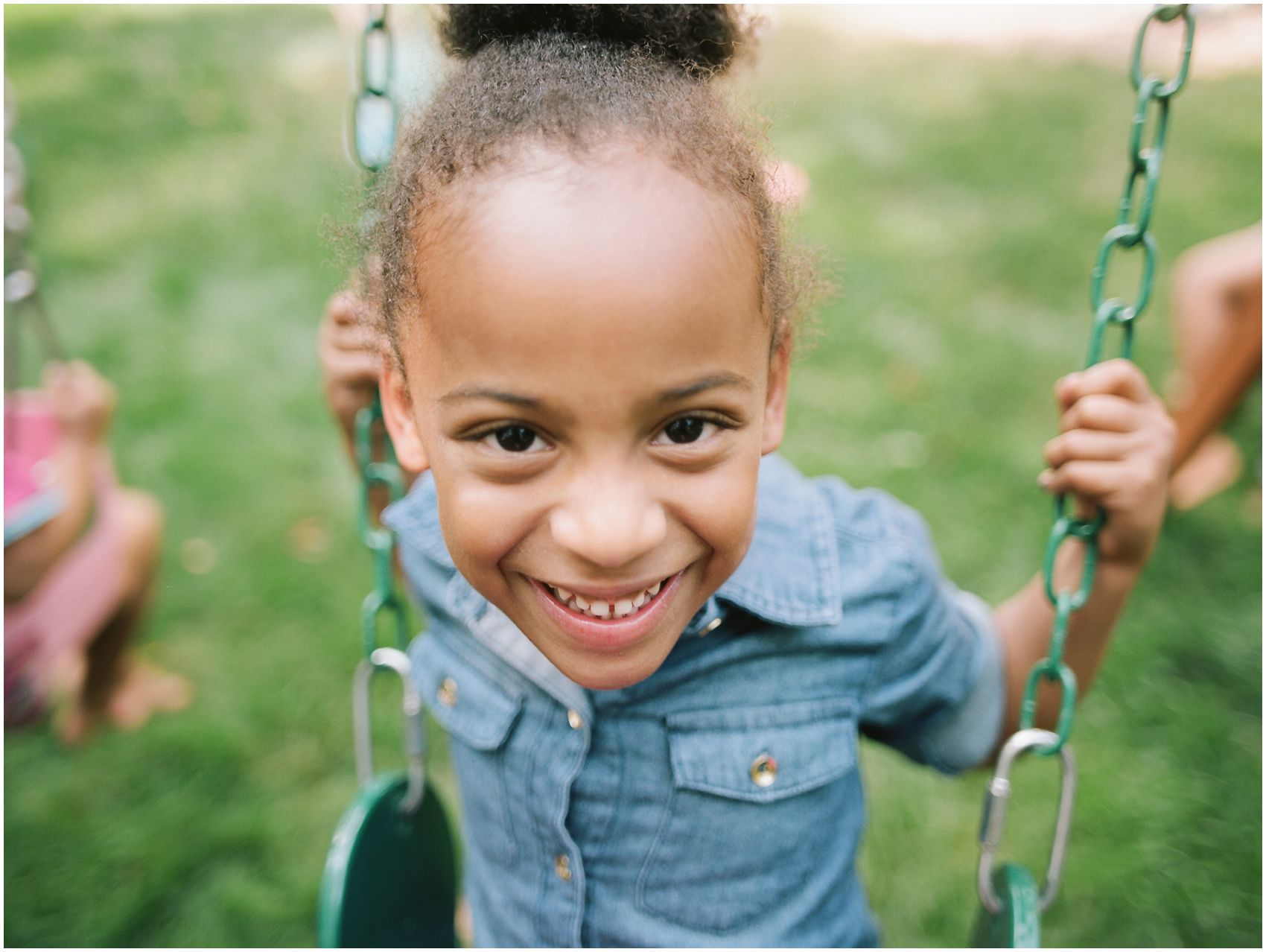 smiling and laughing girl on a swing in her Upper Montclair NJ backyard