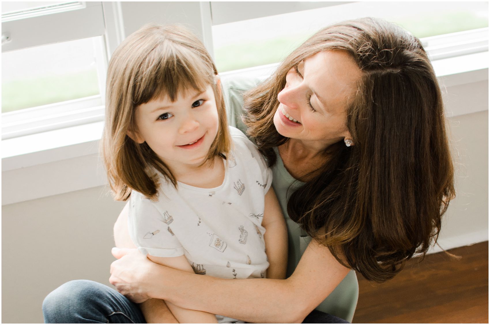 mommy is hugging her little smiling girl in Manhattan