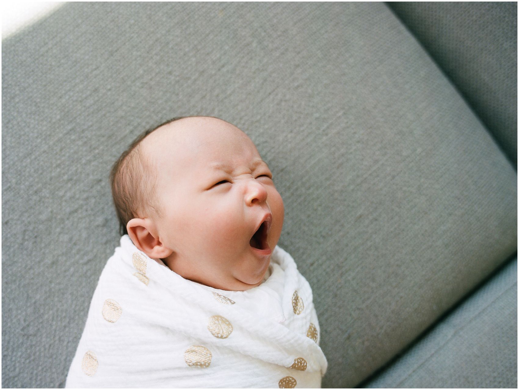newborn baby girl is yawning in newborn portraits taken in NYC