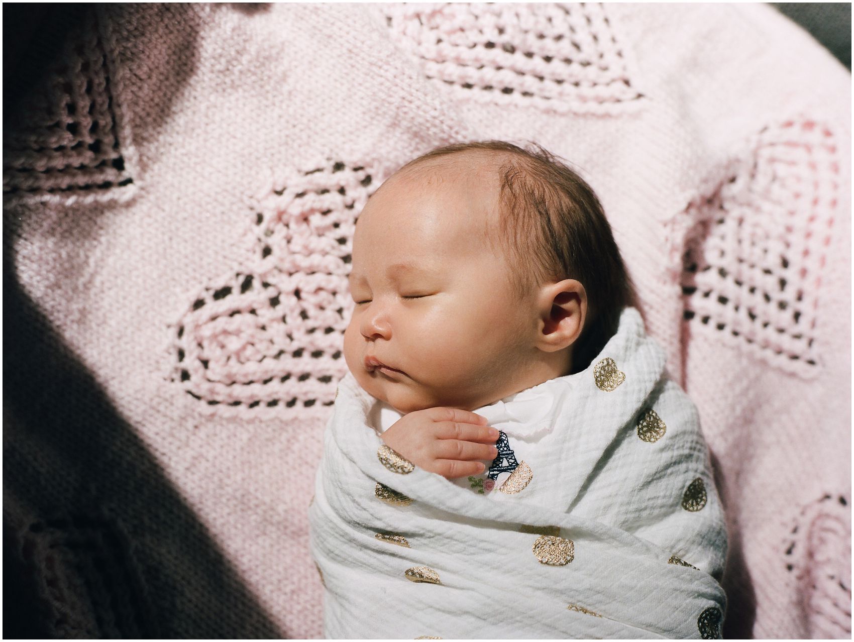 newborn baby girl sleeping in a sunlight on a personal item like handmade pink blanket in NYC