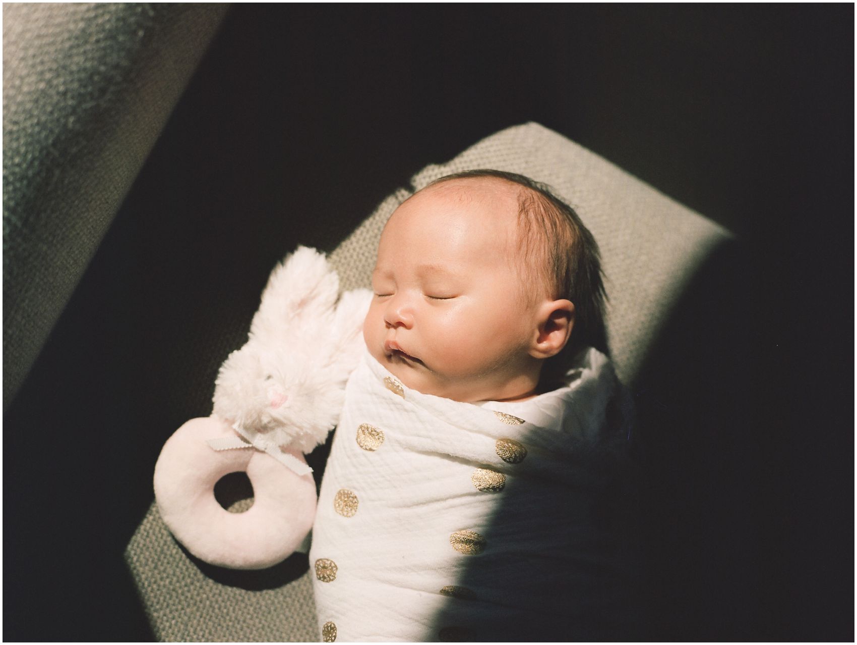using personal items in a portrait of a baby girl sleeping in the sun with her favorite bunny soft toy in NYC
