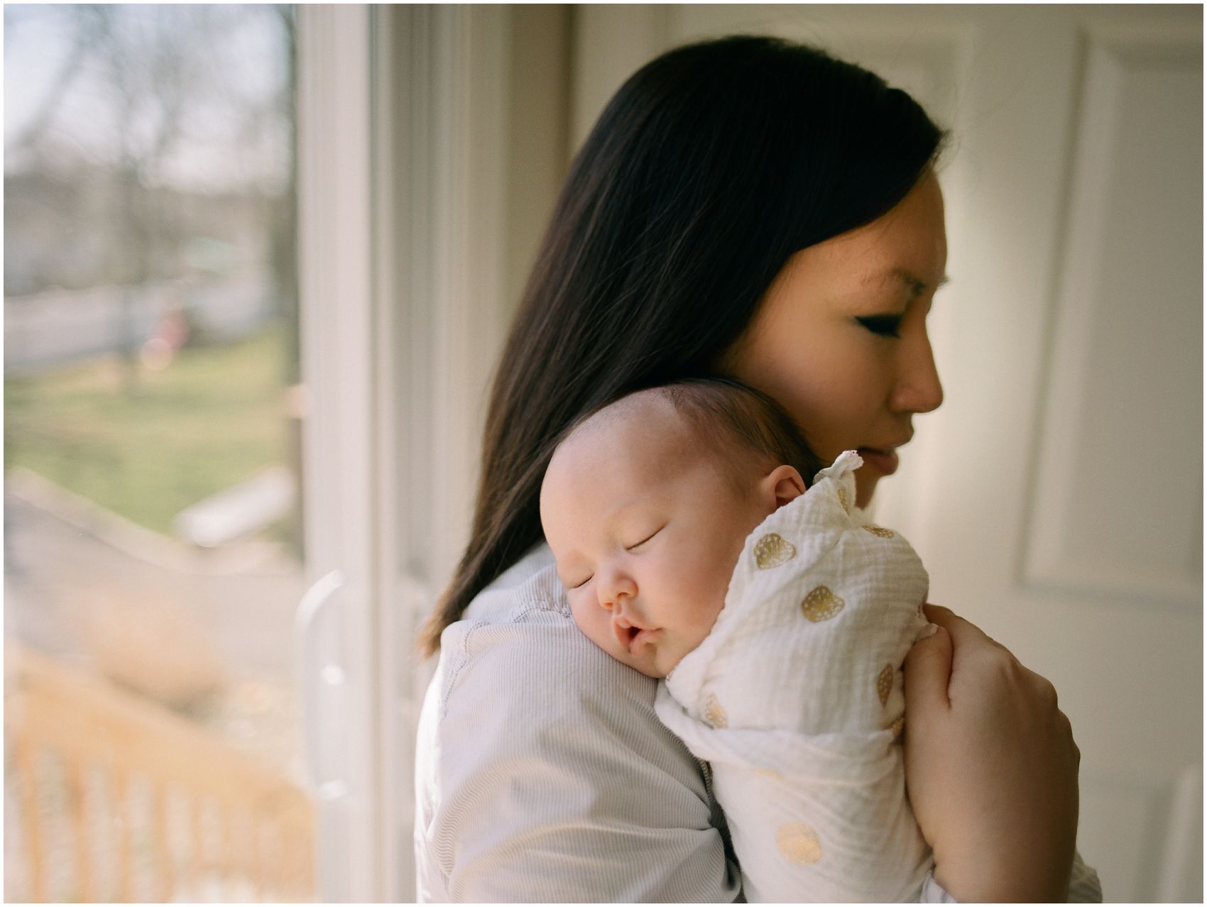 little baby girl is sleeping on her mom shoulder in newborn portrait taken in NYC