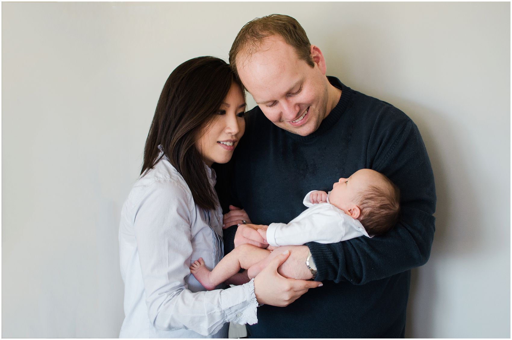 Best NYC newborn photographer takes a photo of a mom and dad adoring and interacting with their baby girl