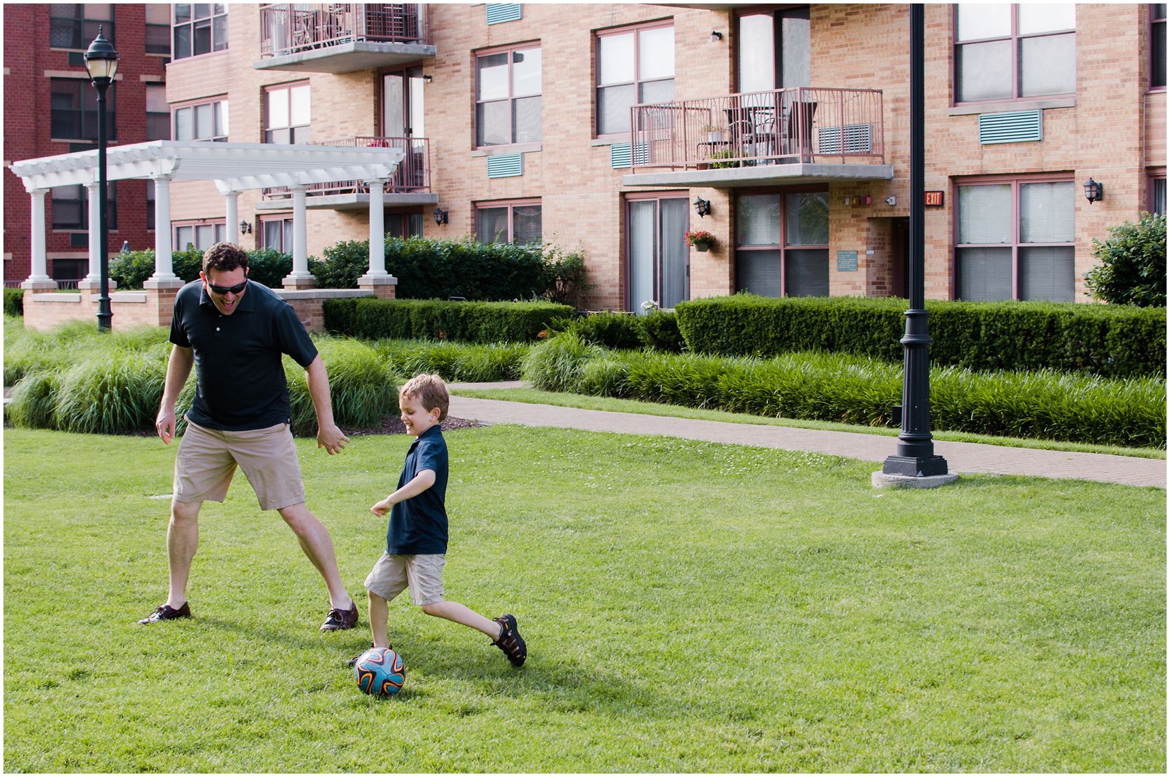 Family fun in the summer is dad playing a ball with his son in their Hoboken NJ roof deck.