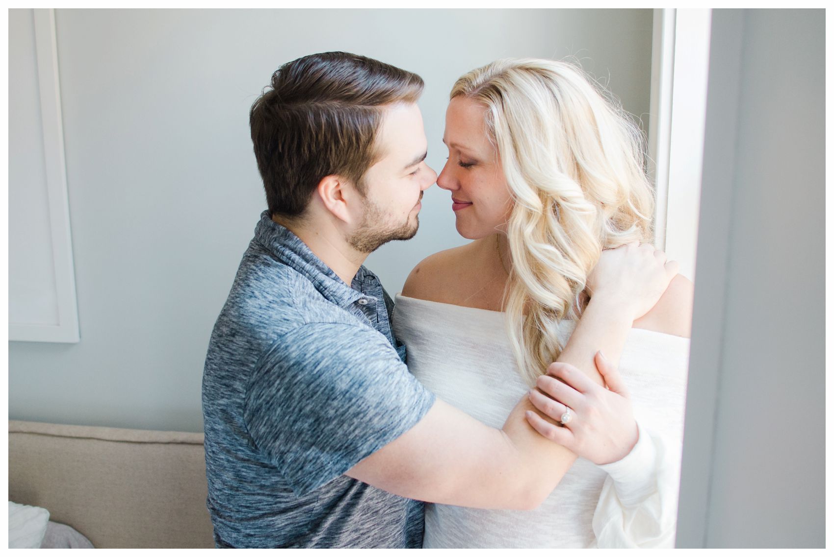pregnant mom and dad embraced by the window for maternity photos in Hoboken NJ