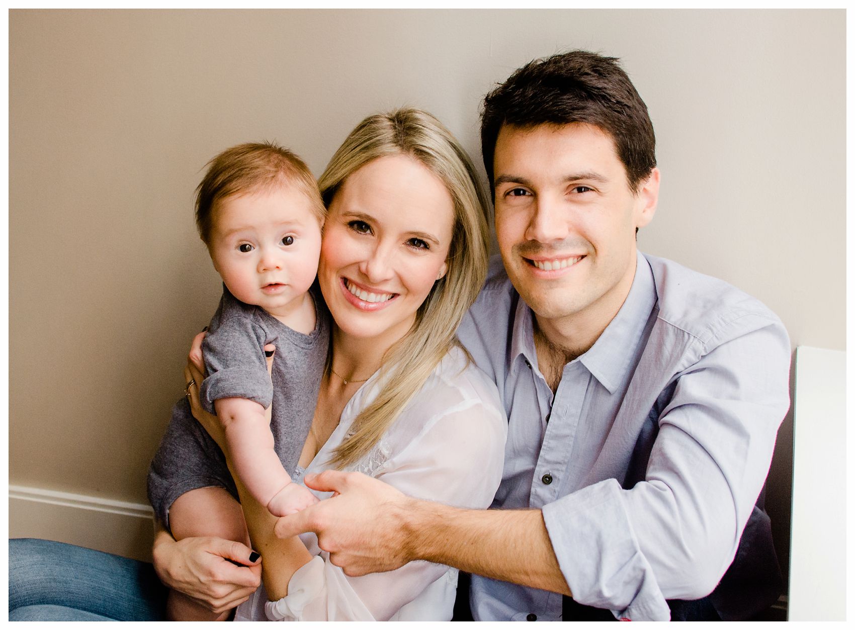 best family photographer taking a portrait of a mom and dad snuggling with their 5 months old baby boy in Hoboken NJ
