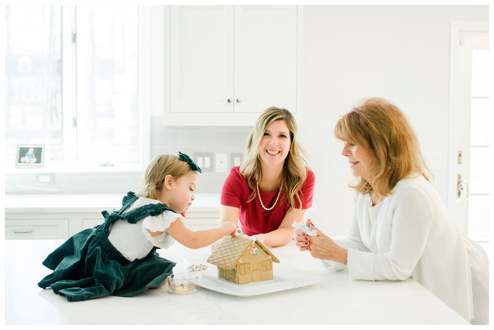three generations of women are building a ginger bread house in their Essex County home