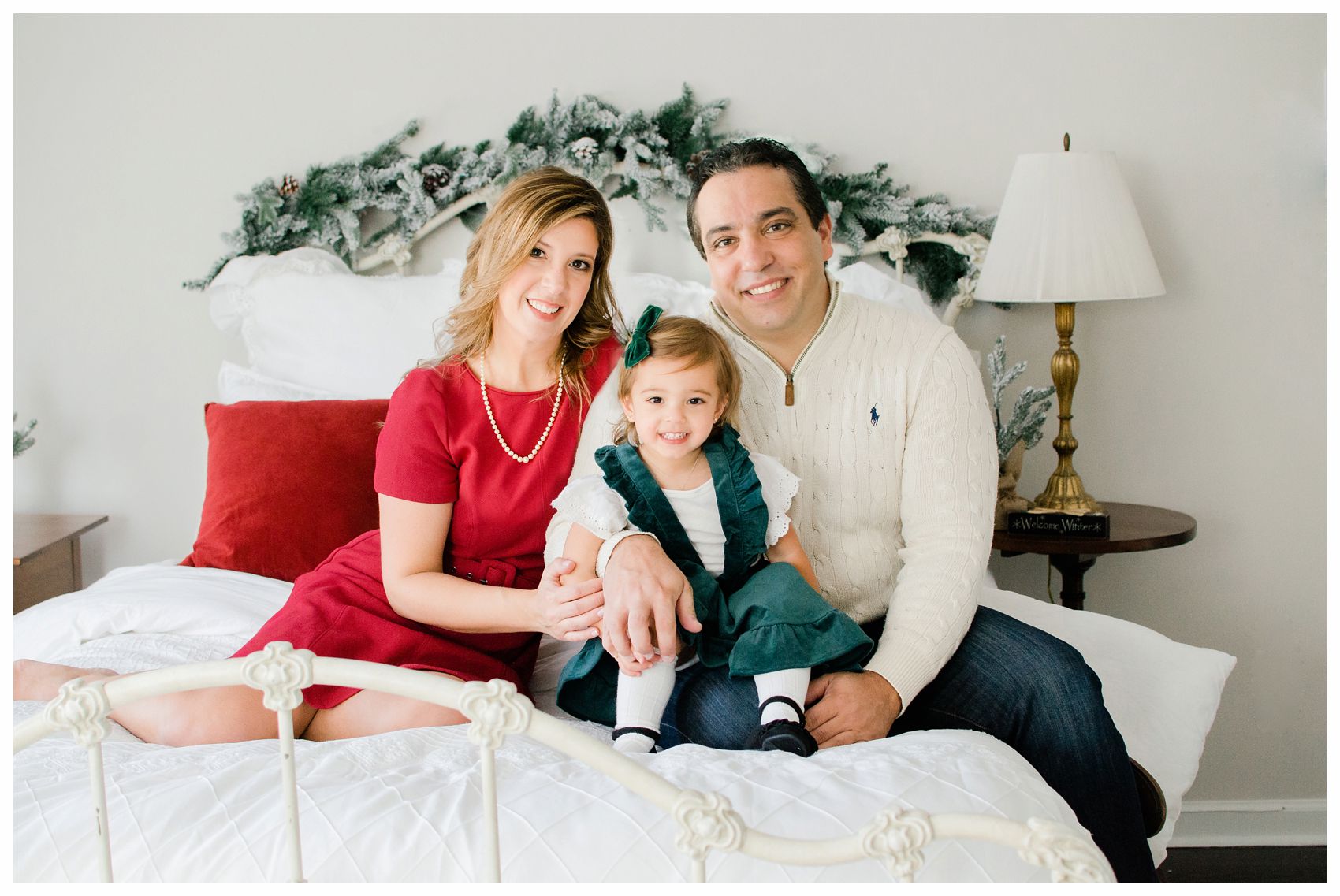 family holiday photo shoot at NJ home on the bed with mom dad and little girl