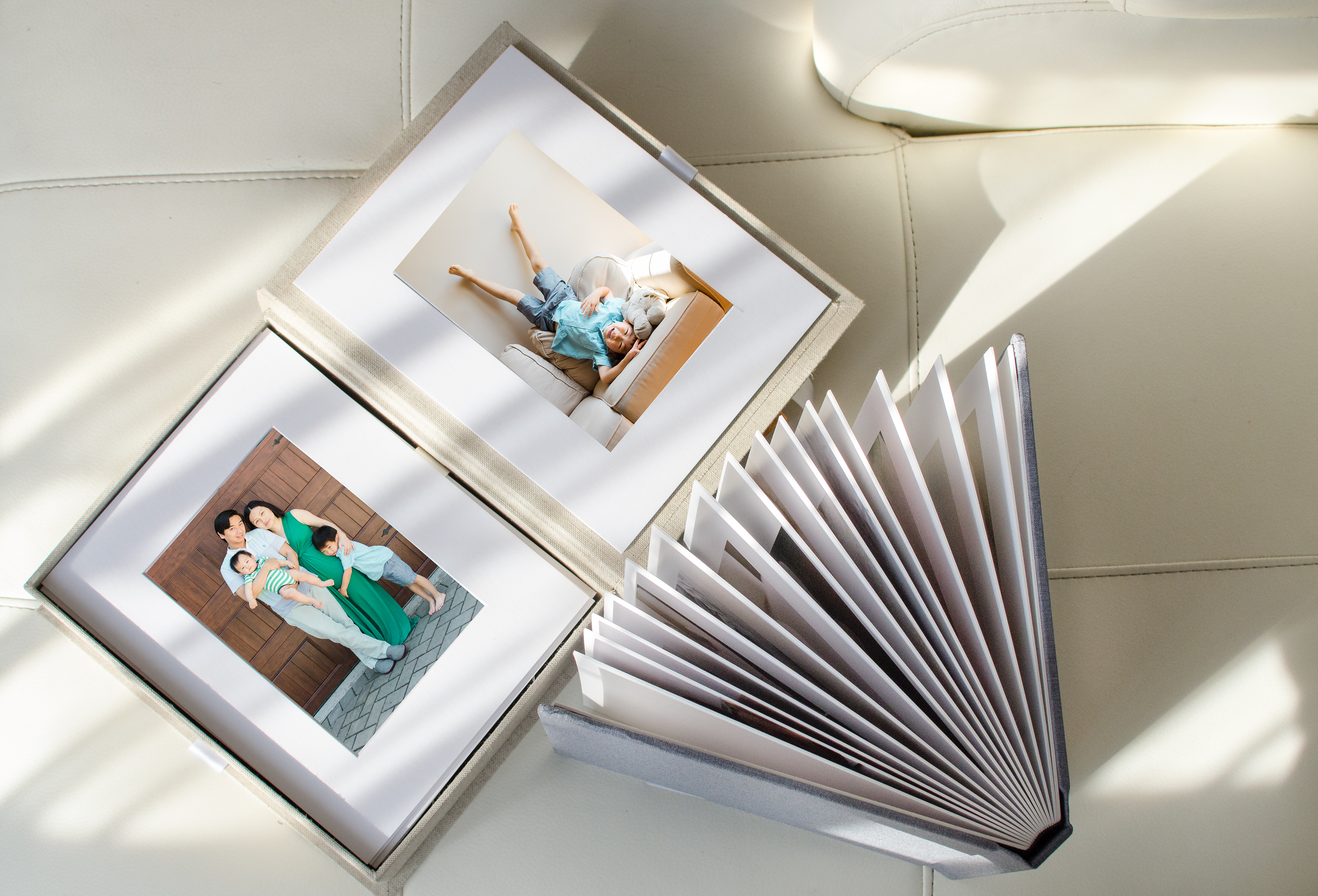 Album and fine art prints on a couch with family portrait 